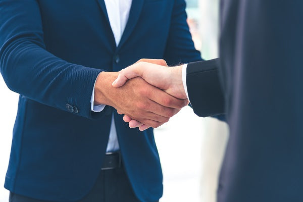 2 businessmen in suits shaking hands